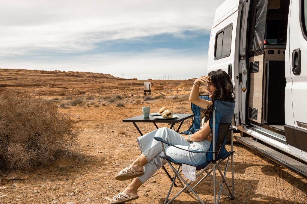 Indie Campers Solis USA, Seitenansicht mit Campingtisch und Stuhl