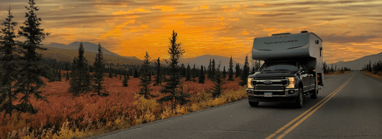 Go North Truck Camper auf einer Straße im Yukon im Sonnenuntergang