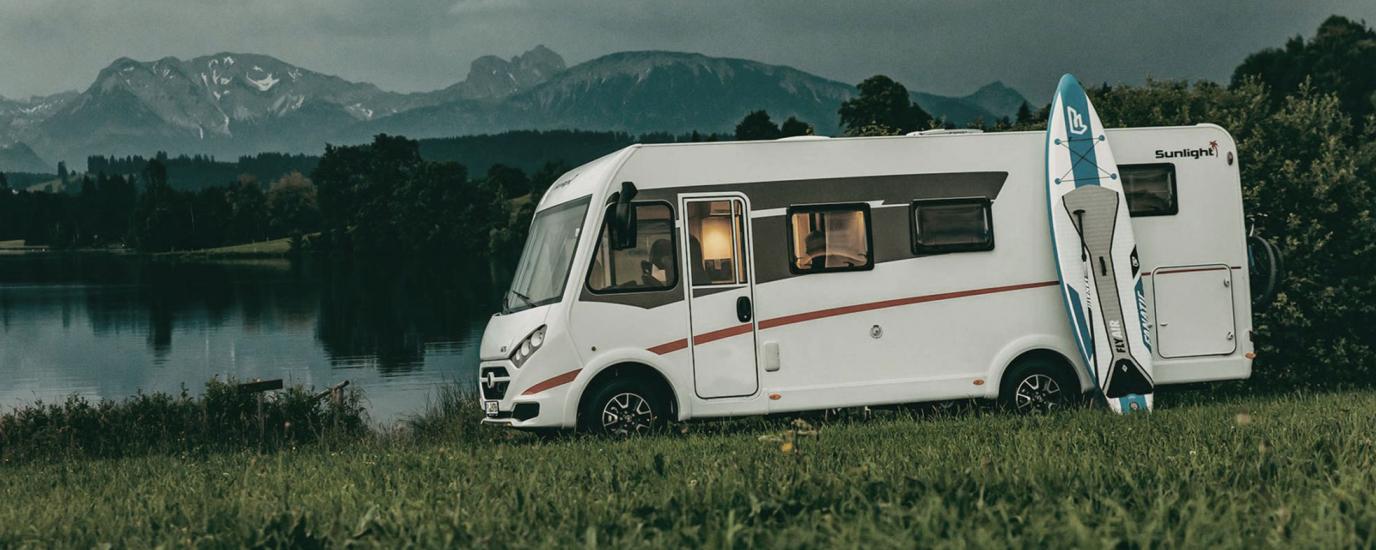 ROADfans Wohnmobil an einem See mit angelehntem Paddleboard